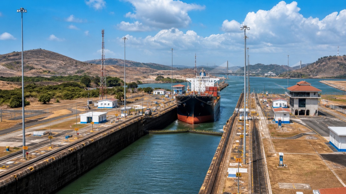 Panama Canal locks and a cargo ship under hot dry-season skies