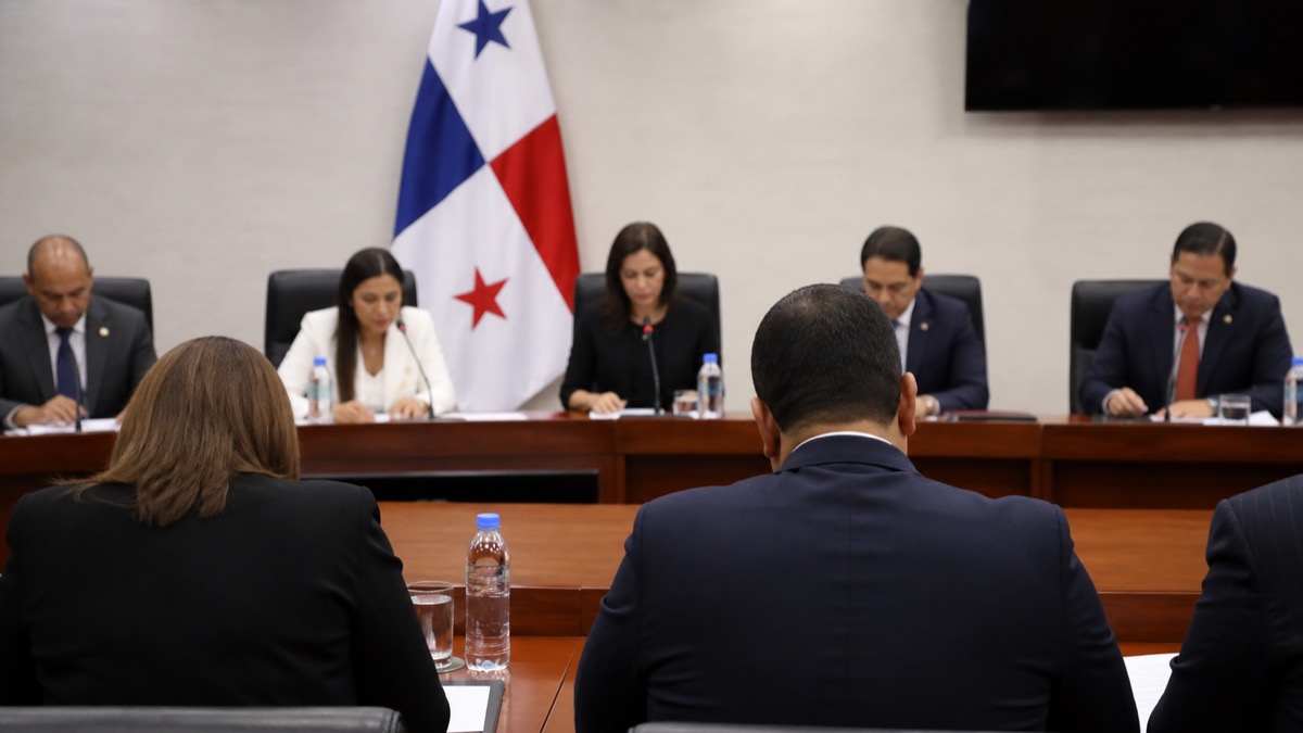 formal legislative oversight hearing in Panama with officials seated at a committee table, no identifiable faces