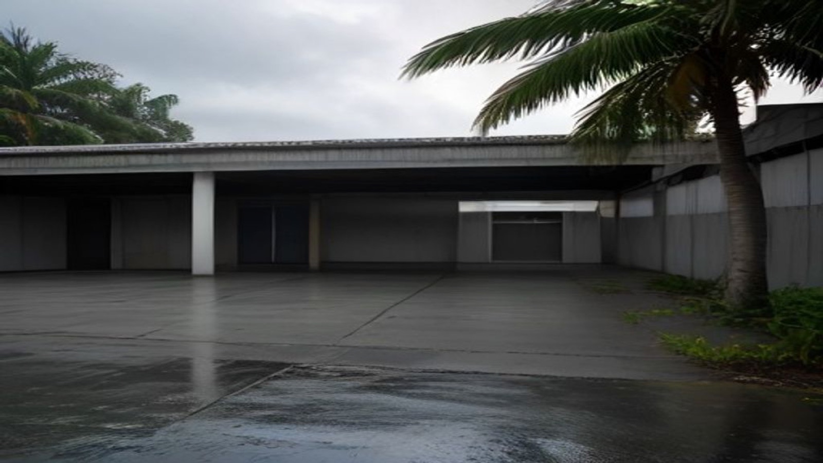 An empty school yard and covered walkway during heavy rain.