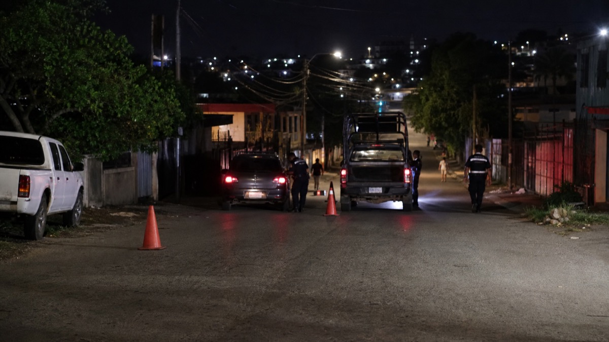 night police patrol checkpoint on an urban San Miguelito street, distant figures