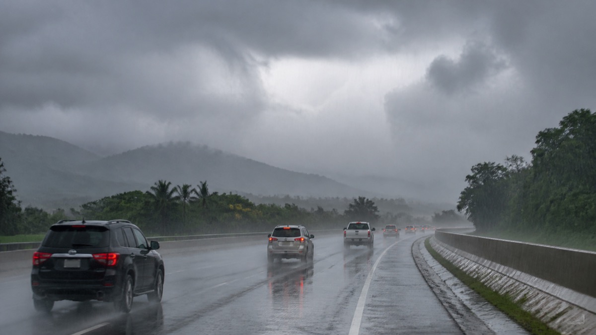 powerful tropical thunderstorm over a Panama highway with heavy rain and cautious traffic
