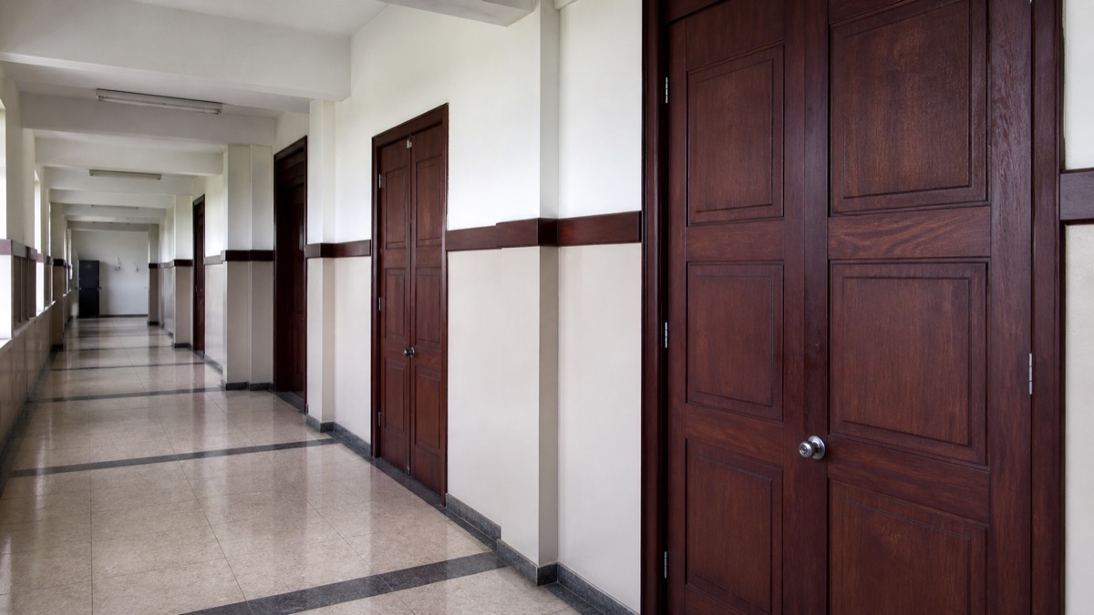 somber Panama courthouse corridor with closed courtroom doors, no people