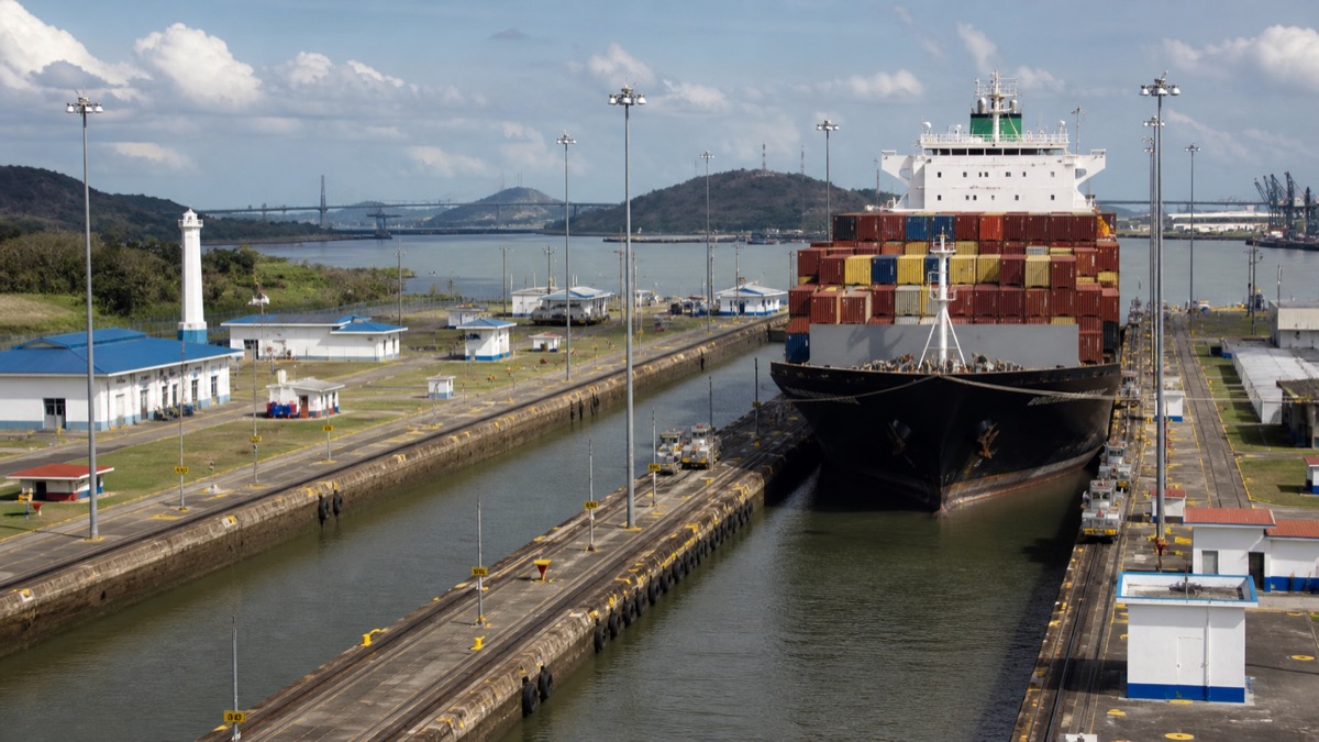 cargo ship passing through Panama Canal locks under dry-season skies