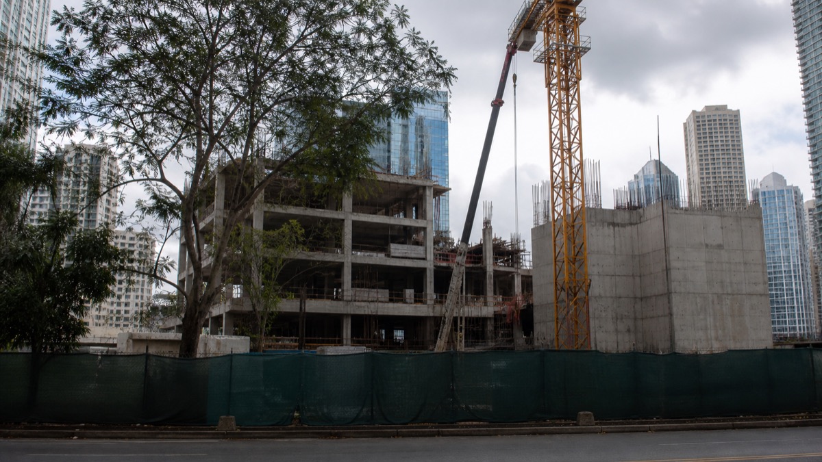 inactive urban construction site in Bella Vista behind secure fencing, no workers