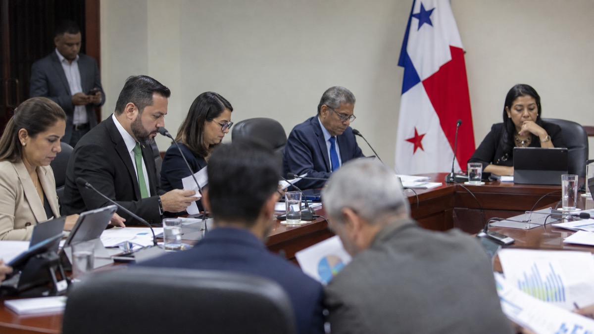neutral election-finance policy discussion in Panama with generic officials reviewing abstract budget charts in a committee room, no readable text