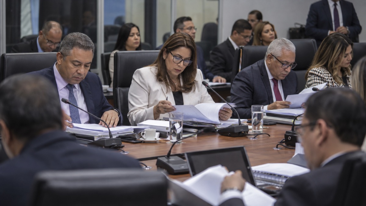 neutral Panama legislative committee room with generic officials reviewing retirement policy folders, no flags or readable text
